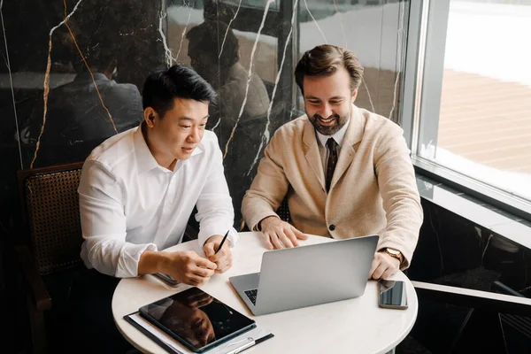 Adult Multiracial Businessmen Talking Using Laptop While Sitting Table Indoors — Stock Photo, Image