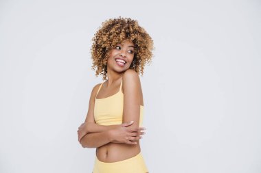 Young black woman wearing underclothes smiling and posing at camera isolated over white background
