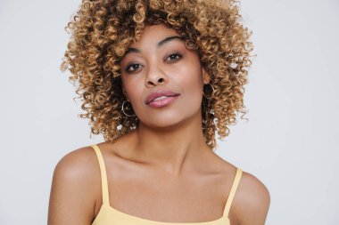 Young black woman wearing underclothes posing at camera isolated over white background