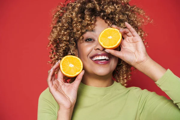 Young Black Woman Afro Curls Having Fun Holding Orange Cut — стоковое фото