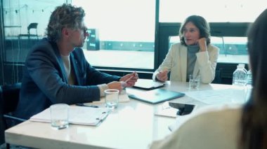 Surprised man and woman colleagues talking about work at the office table