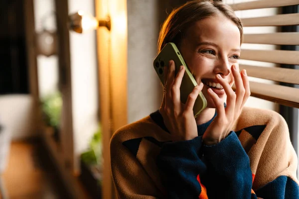 Mooie Jonge Vrouw Kleurrijke Trui Lachen Terwijl Praten Mobiele Telefoon — Stockfoto