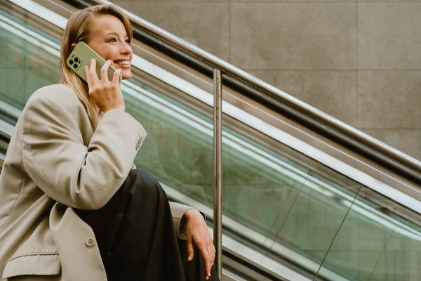 Genç Güzel Mutlu Gülümseyen Kadını Dışarıda Merdivenlerde Otururken Telefonuyla Konuşuyor — Stok fotoğraf