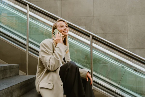 Genç Güzel Mutlu Gülümseyen Kadını Dışarıda Merdivenlerde Otururken Telefonuyla Konuşuyor — Stok fotoğraf