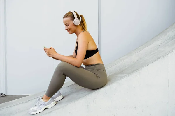 Young Beautiful Smiling Sporty Woman Headphones Holding Using Her Phone — Stock Photo, Image