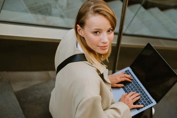 Young White Woman Smiling Using Laptop While Sitting Stairs Outdoors — Stok fotoğraf