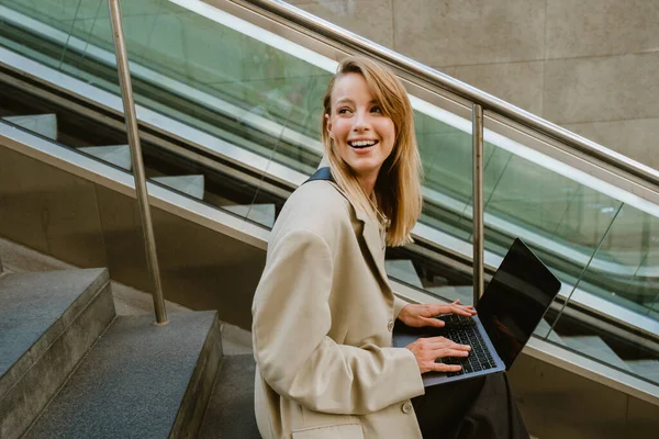 Genç Beyaz Kadın Dışarıda Merdivenlerde Otururken Gülümsüyor Dizüstü Bilgisayar Kullanıyor — Stok fotoğraf