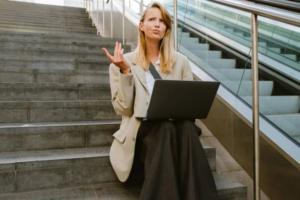 Young White Serious Woman Using Laptop While Sitting Stairs Outdoors — Stockfoto