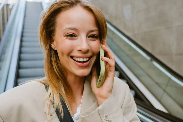 Mladá Bílá Žena Usmívá Mluví Mobilu Zatímco Jde Dolů Eskalátor — Stock fotografie