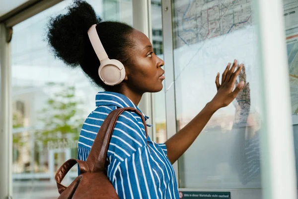 Young African Woman Headphones Pointing Train Map Route — Foto de Stock