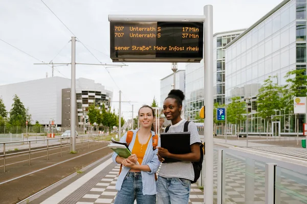 Young Multiracial Student Women Smiling Together While Standing Bus Station — Stockfoto