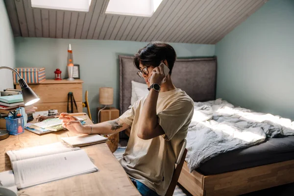 Asian Teenage Guy Using Cellphone While Sitting Desk Studying Home — Stok fotoğraf