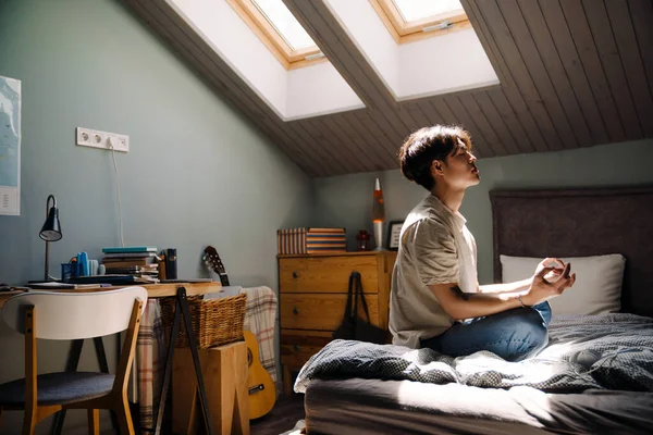 Young Asian Man Wearing Shirt Meditating While Sitting Bed Home — ストック写真