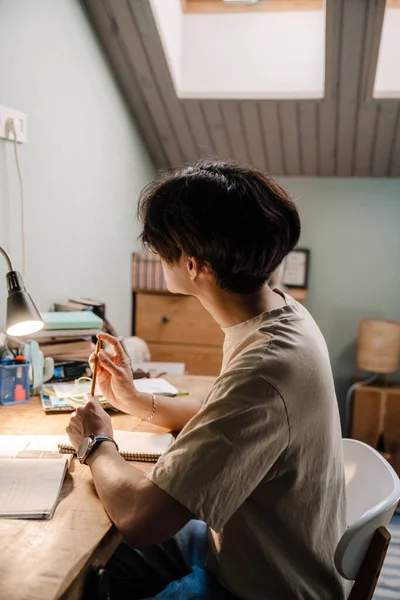Ciddi Asyalı Genç Adam Evde Masa Başında Otururken Kitapla Çalışıyor — Stok fotoğraf