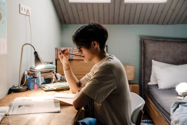 Serious Asian Teenage Guy Studying Book While Sitting Desk Home — Foto de Stock