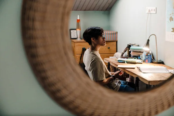 Серьезный Азиатский Подросток Учится Книгой Сидя Столом Дома — стоковое фото