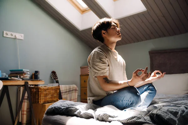 Young Asian Man Wearing Shirt Meditating While Sitting Bed Home — Stok fotoğraf