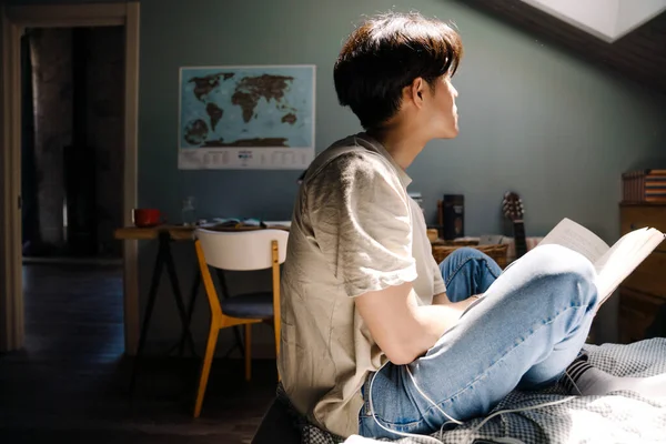 Young Asian Man Wearing Shirt Reading Book While Sitting Bed — Foto de Stock