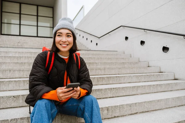 Beautiful Young Smiling Asian Woman Backpack Using Smartphone While Sitting —  Fotos de Stock