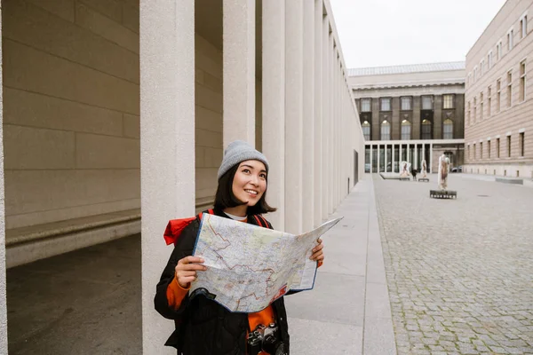 Mladá Radostná Asijská Žena Teplých Šatech Zkoumá Papírové Mapy Během — Stock fotografie