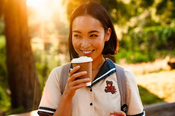Young Smiling Asian Woman Backpack Drinking Coffee While Walking Outdoors — Fotografia de Stock