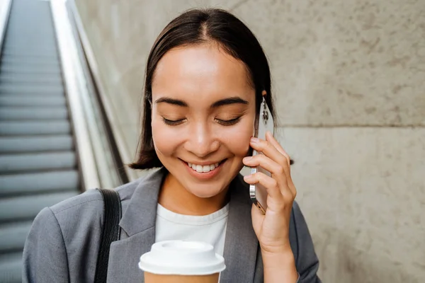 Jovem Sorrindo Asiático Mulher Bebendo Café Falando Telefone Celular Enquanto — Fotografia de Stock