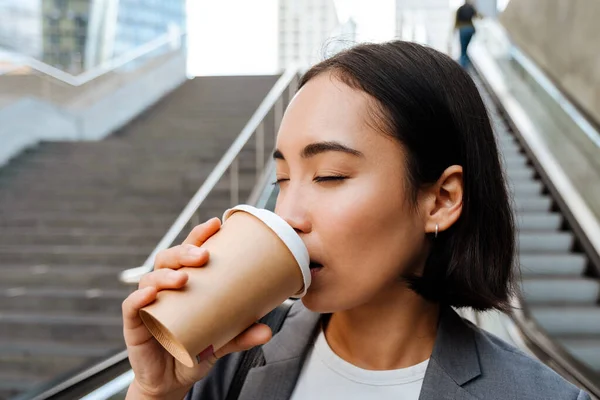 Mladá Asijská Žena Nosí Oblek Pití Kávy Zatímco Stojí Eskalátoru — Stock fotografie