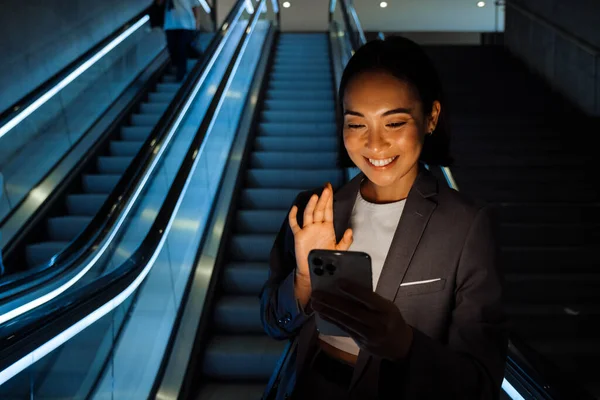 Genç Gülümseyen Asyalı Kadın Içeride Yürüyen Merdivende Kameraya Sallıyor — Stok fotoğraf