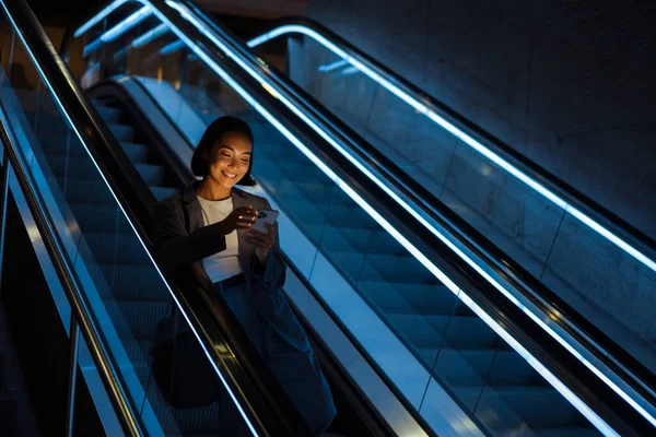 Genç Neşeli Asyalı Kadın Içeride Yürüyen Merdivende Dururken Cep Telefonu — Stok fotoğraf