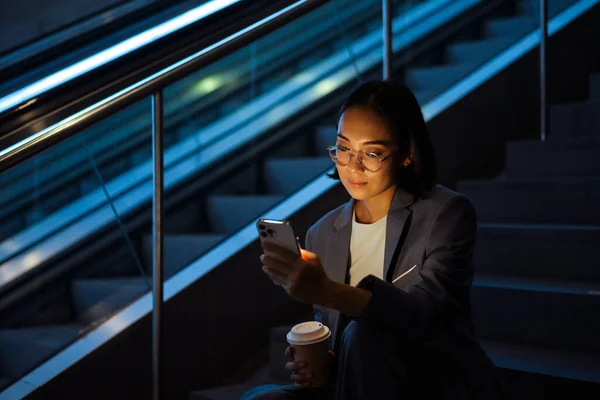 Gözlüklü Genç Asyalı Kadın Cep Telefonu Kullanıyor Merdivenlerde Otururken Kahve — Stok fotoğraf