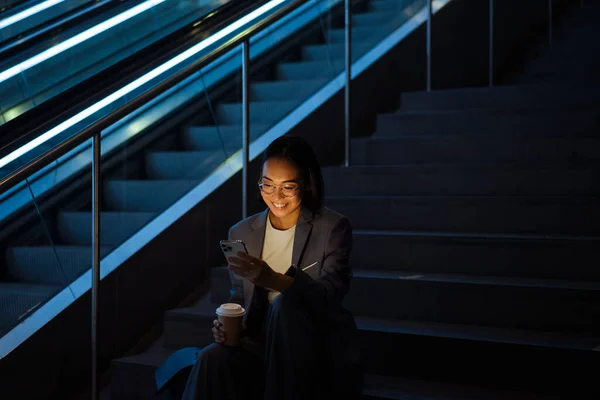 Gözlüklü Cep Telefonu Kullanan Merdivenlerde Otururken Kahve Içen Asyalı Genç — Stok fotoğraf