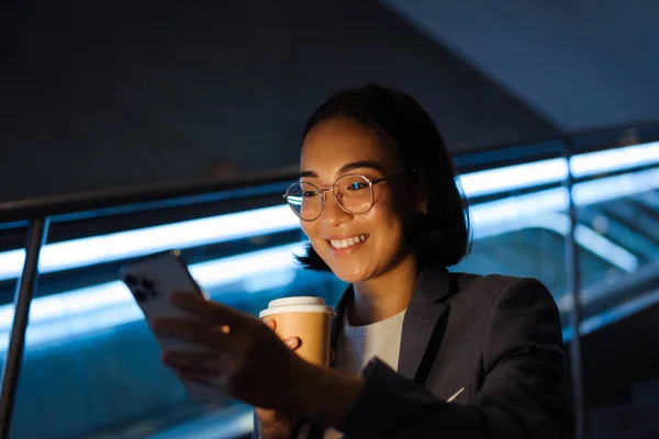 Young Smiling Asian Woman Eyeglasses Using Mobile Phone Drinking Coffee — Stok fotoğraf