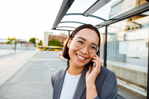 Young Smiling Asian Woman Glasses Talking Mobile Phone While Standing — Fotografia de Stock