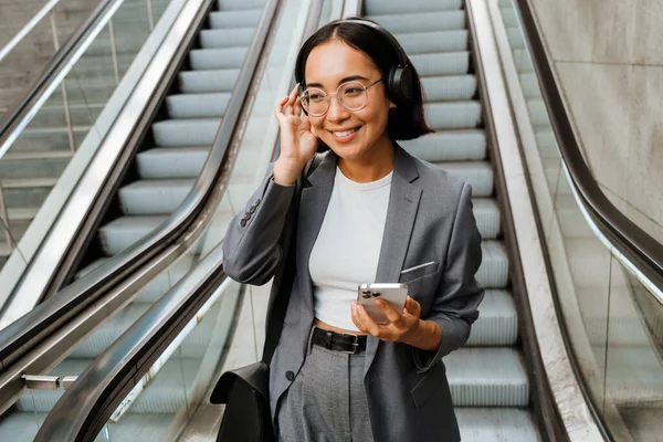 Kulaklıklı Genç Asyalı Kadın Dışarıda Yürüyen Merdivende Dururken Gülümsüyor Akıllı — Stok fotoğraf
