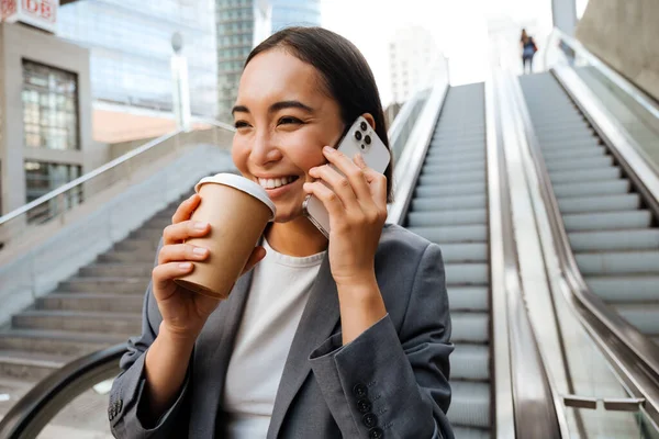 Young Asian Woman Talking Cellphone Drinking Coffee While Standing Escalator — Stok fotoğraf