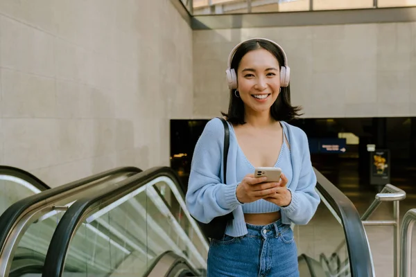 Joven Mujer Asiática Con Auriculares Uso Teléfono Móvil Mientras Que — Foto de Stock