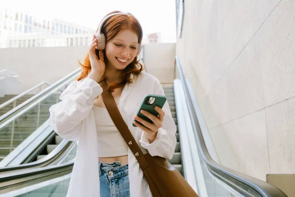 Mujer Blanca Joven Que Usa Auriculares Usando Teléfono Móvil Mientras — Foto de Stock