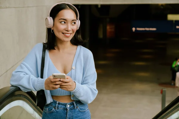 Jovem Mulher Asiática Sorrindo Usando Celular Enquanto Está Escada Rolante — Fotografia de Stock