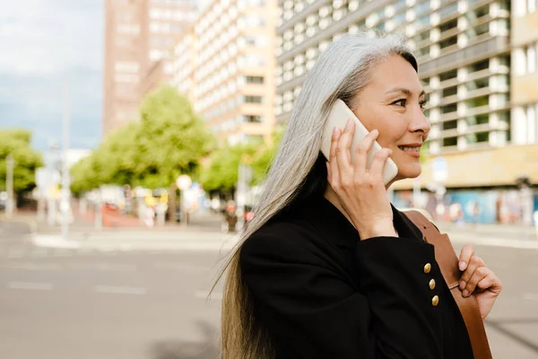 Grey Asian Woman Smiling Talking Cellphone City Street — Zdjęcie stockowe