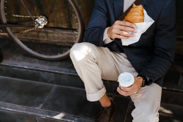 Closeup Man Holding Cup Coffee Croissant Sitting Bicycle Outdoors City — Stock Fotó