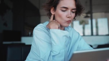 Confident brunette woman designer working on tablet in the office