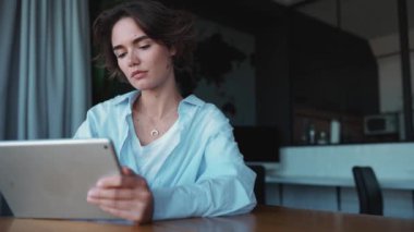 Güzel esmer kadın tasarımcı ofiste tablet üzerinde çalışıyor.
