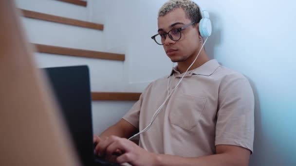 Przystojny Mężczyzna Przekłuwającymi Farbowanymi Blond Włosami Piszący Laptopie Słuchawkach Schodach — Wideo stockowe