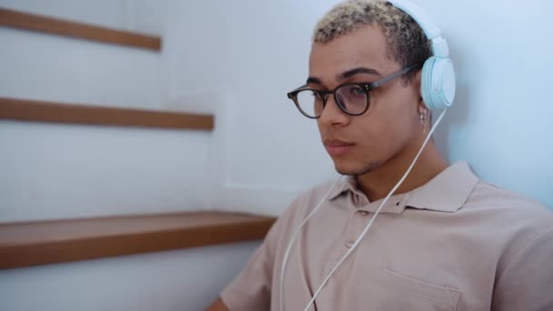 Cute Man Piercing Dyed Blond Hair Working Headphones Stairs Home — Video