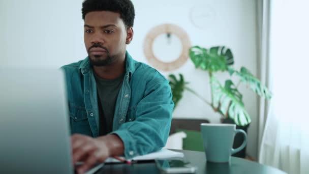 Ernsthafter Afrikanischer Brunet Mann Arbeitet Laptop Während Hause Zimmer Sitzt — Stockvideo
