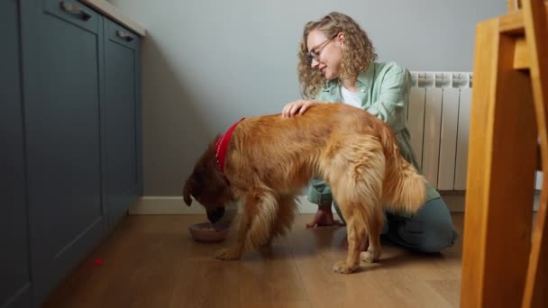 Lovely Curly Haired Woman Stroking Watching Dog Eat Kitchen Home — Video