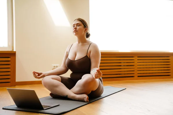 Ingefära Ung Kvinna Som Använder Laptop Och Mediterar Yogautövandet Inomhus — Stockfoto