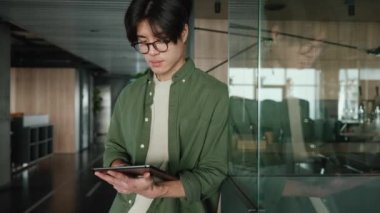 Gözlüklü, iş arkadaşı çalışma odasında tablet yazan kendine güvenen esmer Asyalı adam.