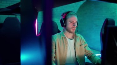 Confident man gamer plays RPG video game on a championship. Stylish Neon Cyber Games