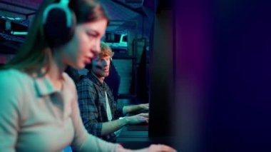 Concentrated red haired man and brunette woman gamers play RPG video game on a championship. Stylish Neon Cyber Games